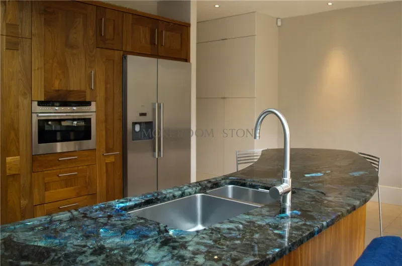 Curved dark countertop with blue mineral highlights and a stainless steel sink