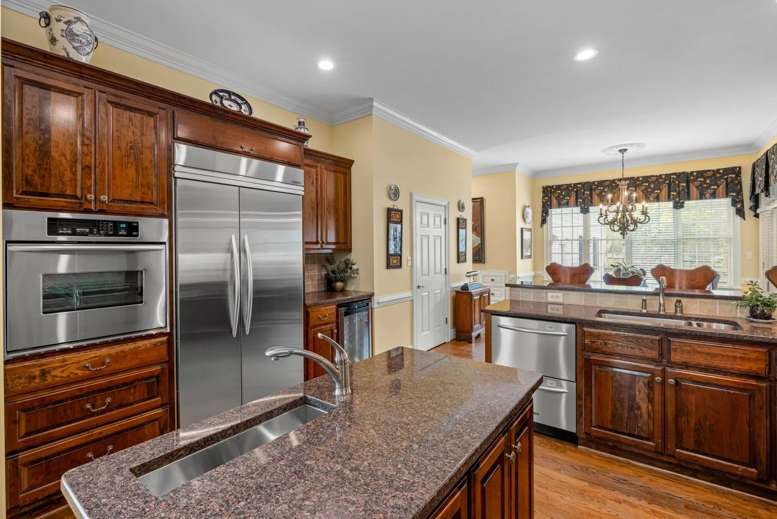 Kitchen with wood cabinets, a patterned island countertop, and stainless steel appliances