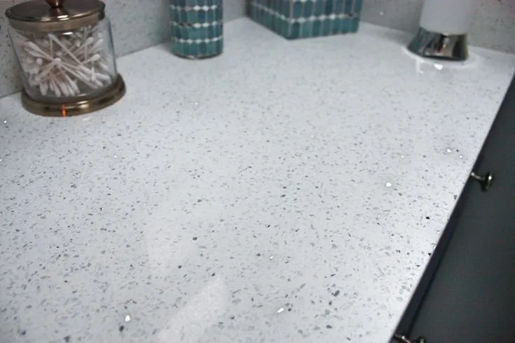 White quartz countertop with fine reflective speckles beside kitchen containers