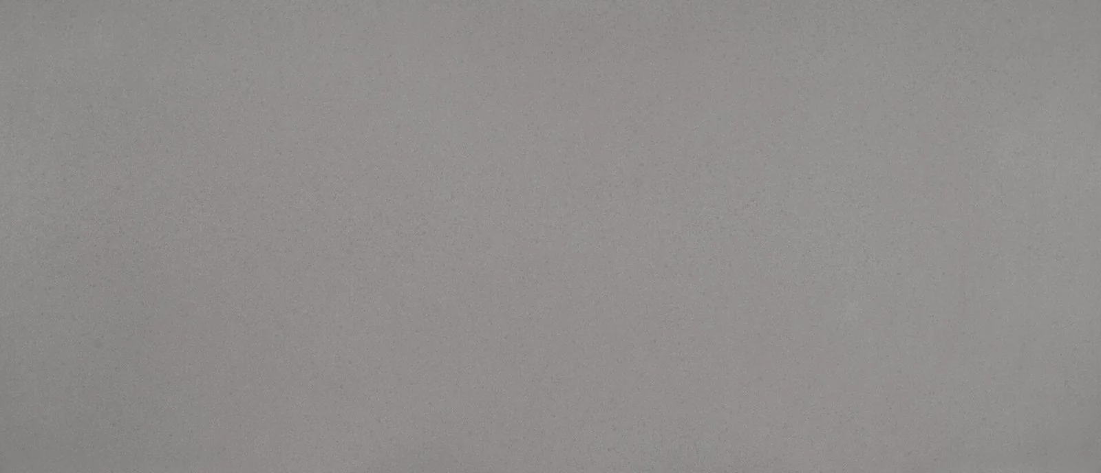 Close-up of a soft gray quartz surface with fine darker speckles