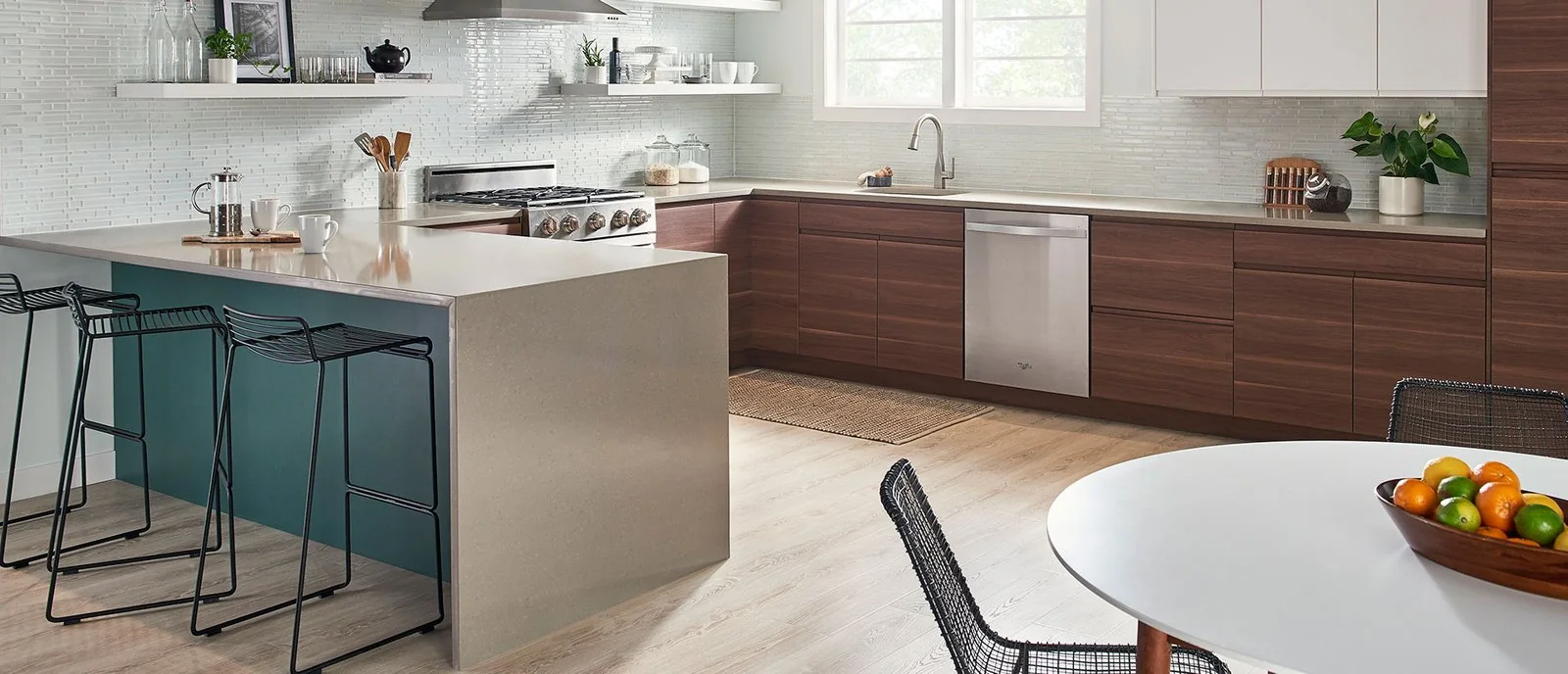 Kitchen with a gray island countertop, bar stools, and wood base cabinets