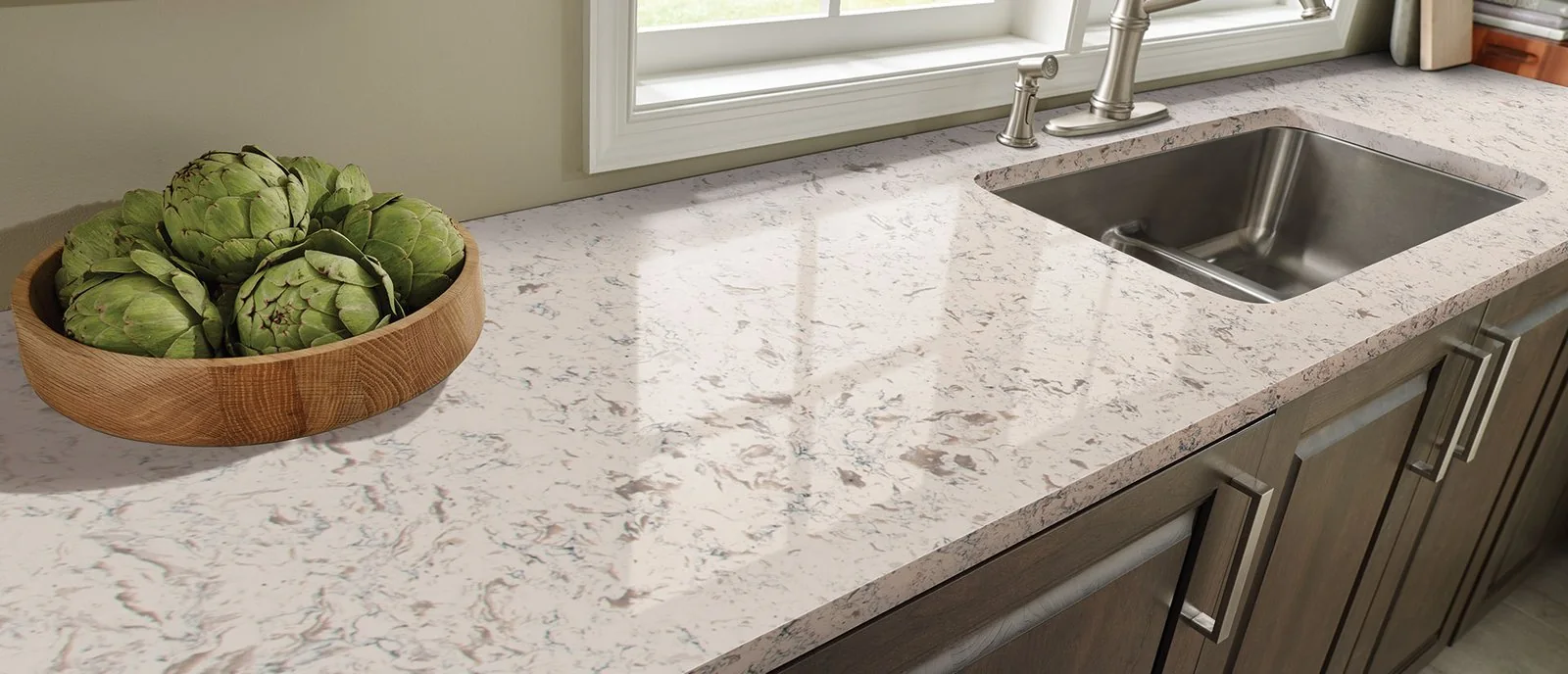 White and gray patterned countertop around a stainless steel sink