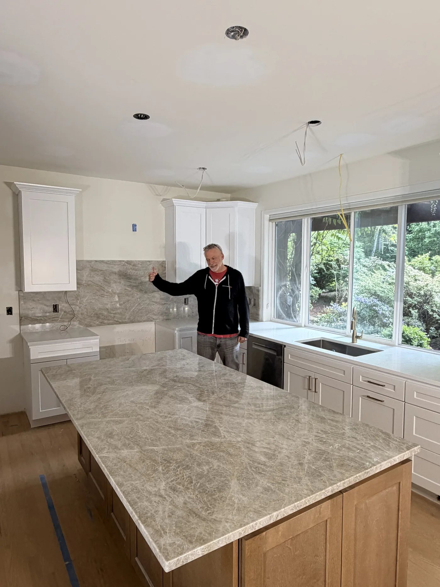 Homeowner giving a thumbs-up beside their finished Top Granite countertop