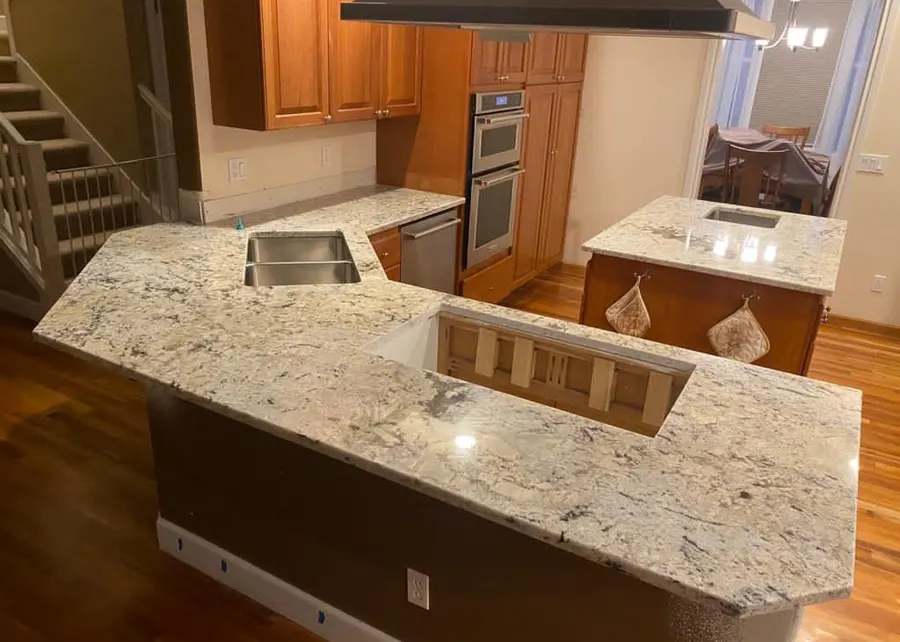 Warm stone, warm wood, a kitchen that feels like home. A Top Granite project