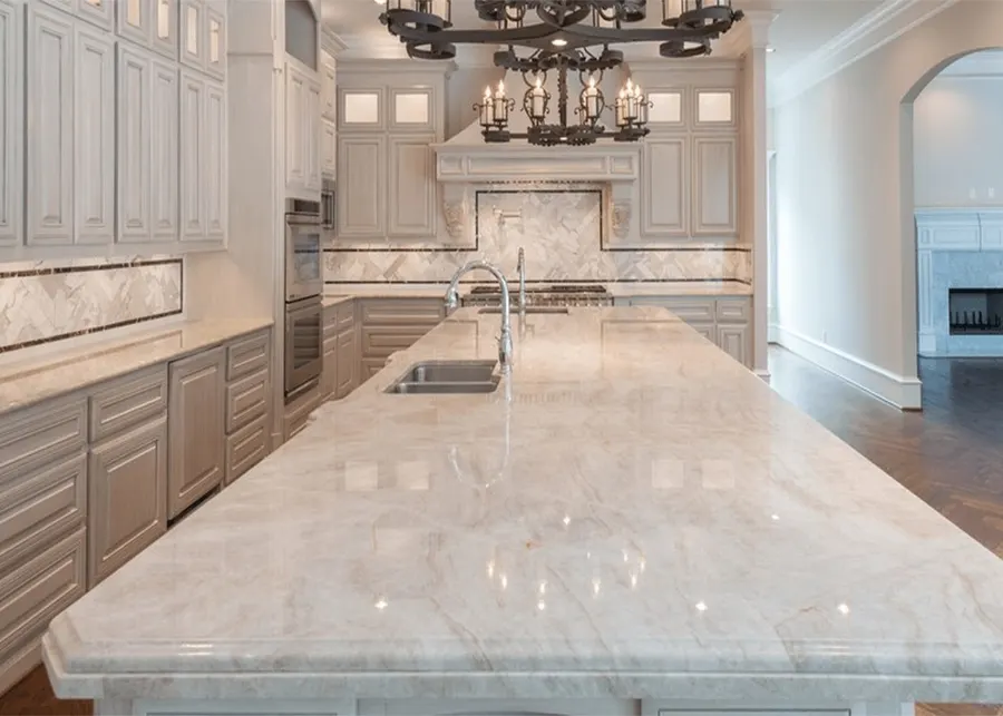 A luxury kitchen with a marble island and chandelier. A Top Granite project