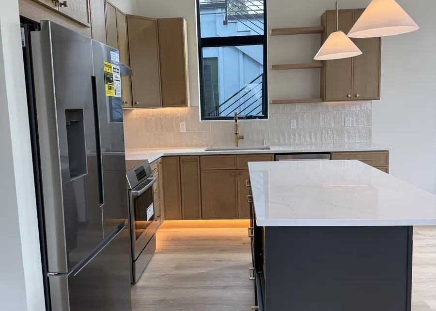 Light wood kitchen with an island and pendants. A Top Granite project