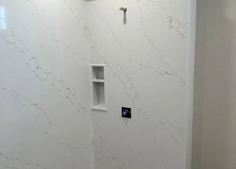 Full-height slab shower walls and vanities. A Top Granite project
