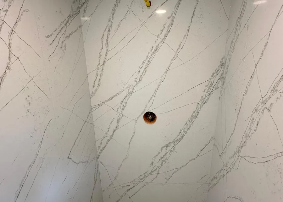 Full-height slab shower walls and vanities. A Top Granite project