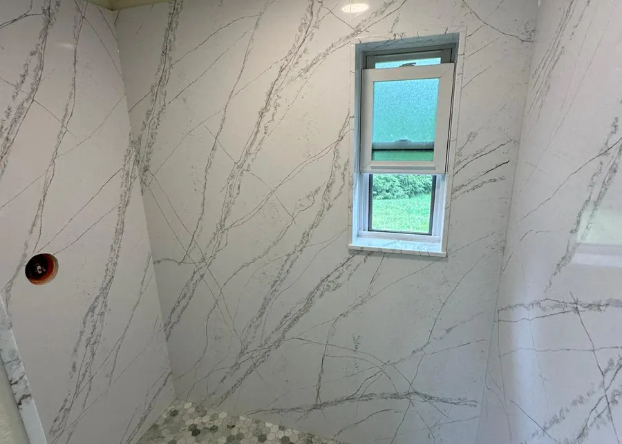 Full-height slab shower walls and vanities. A Top Granite project