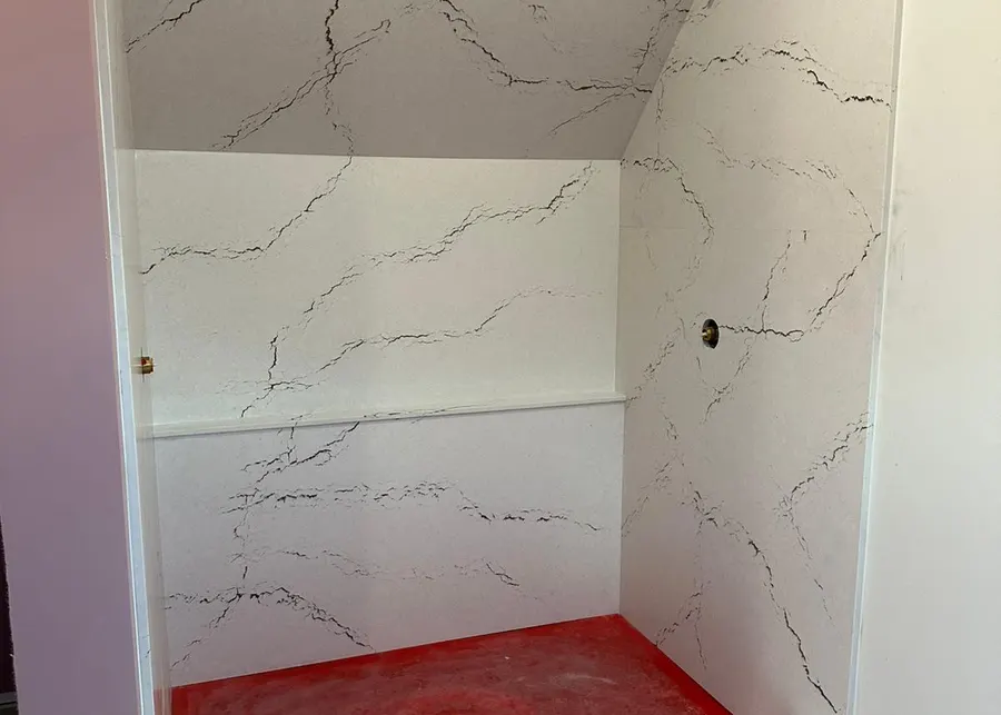 Full-height slab shower walls and vanities. A Top Granite project