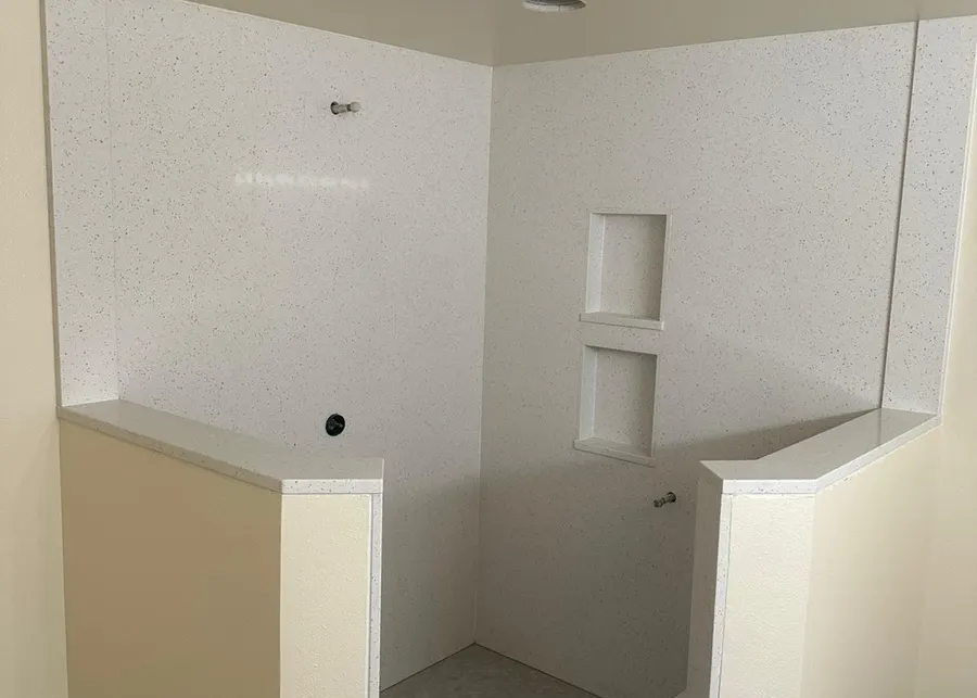 Full-height slab shower walls and vanities. A Top Granite project