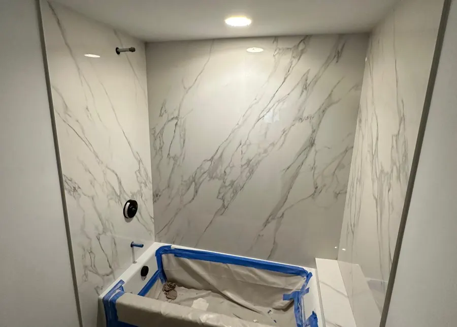 Full-height slab shower walls and vanities. A Top Granite project