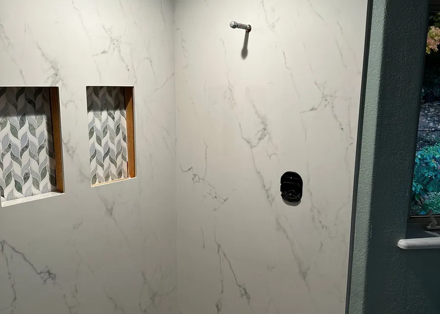 Full-height slab shower walls and vanities. A Top Granite project