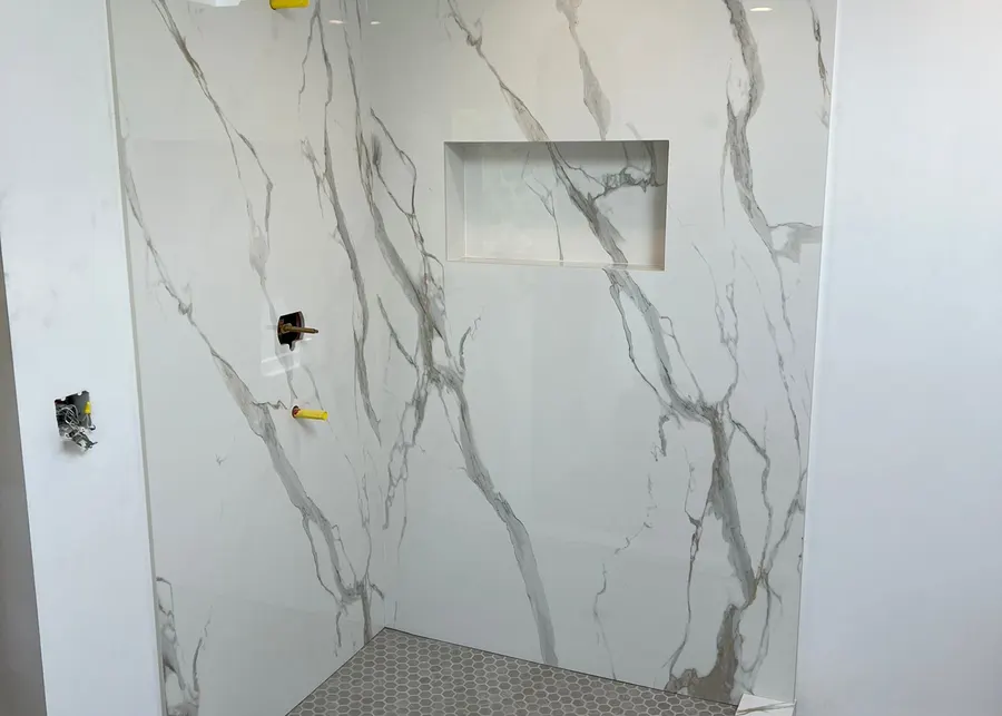 Full-height slab shower walls and vanities. A Top Granite project