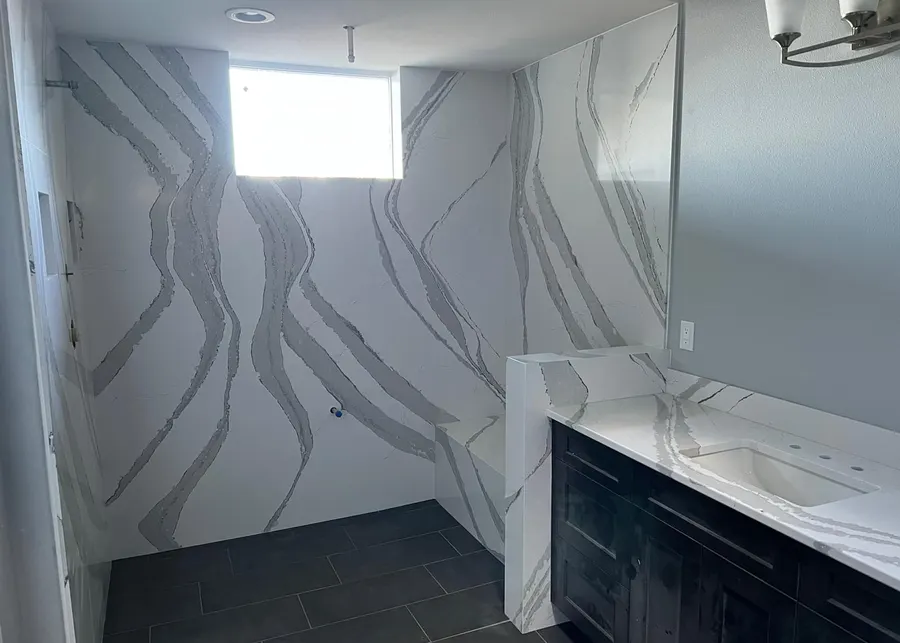 Full-height slab shower walls and vanities. A Top Granite project