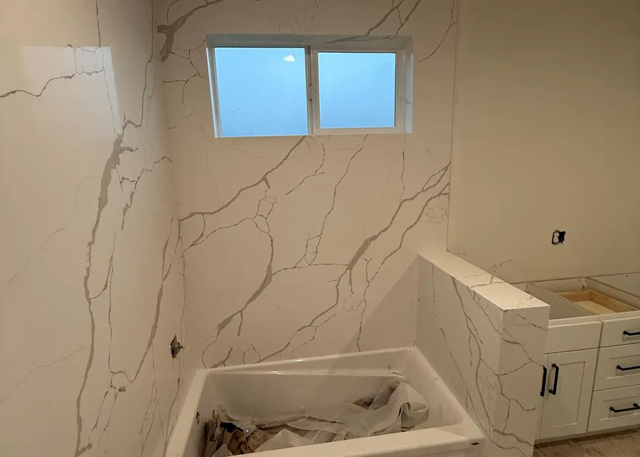Full-height slab shower walls and vanities. A Top Granite project