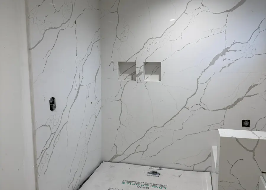 Full-height slab shower walls and vanities. A Top Granite project