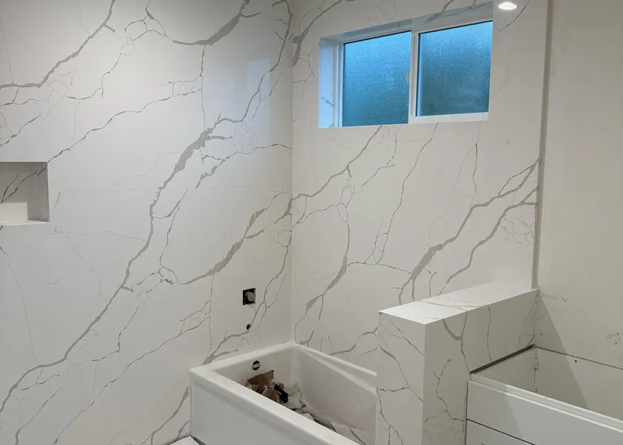 Full-height slab shower walls and vanities. A Top Granite project