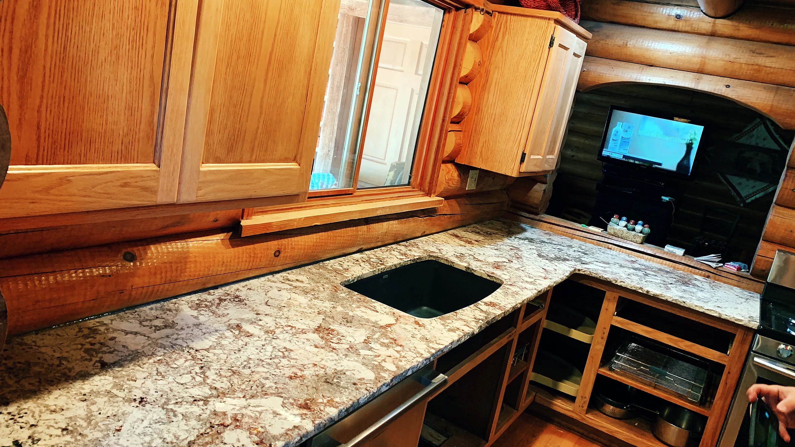 Granite countertop with an undermount sink in a log-home kitchen, installed by Top Granite