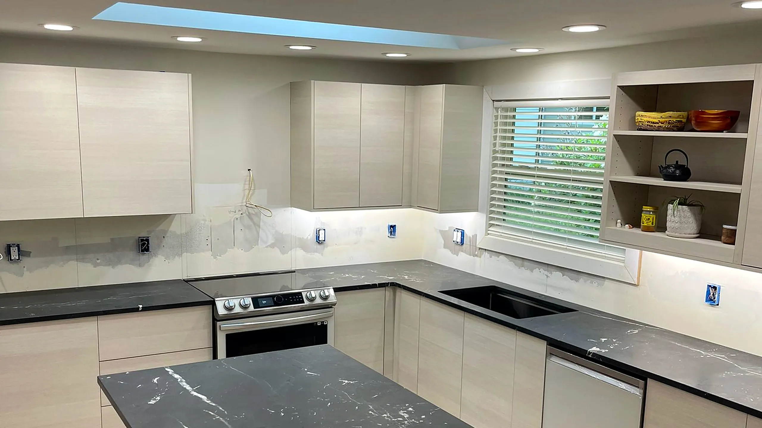 Charcoal soapstone countertops and island in a light modern kitchen by Top Granite