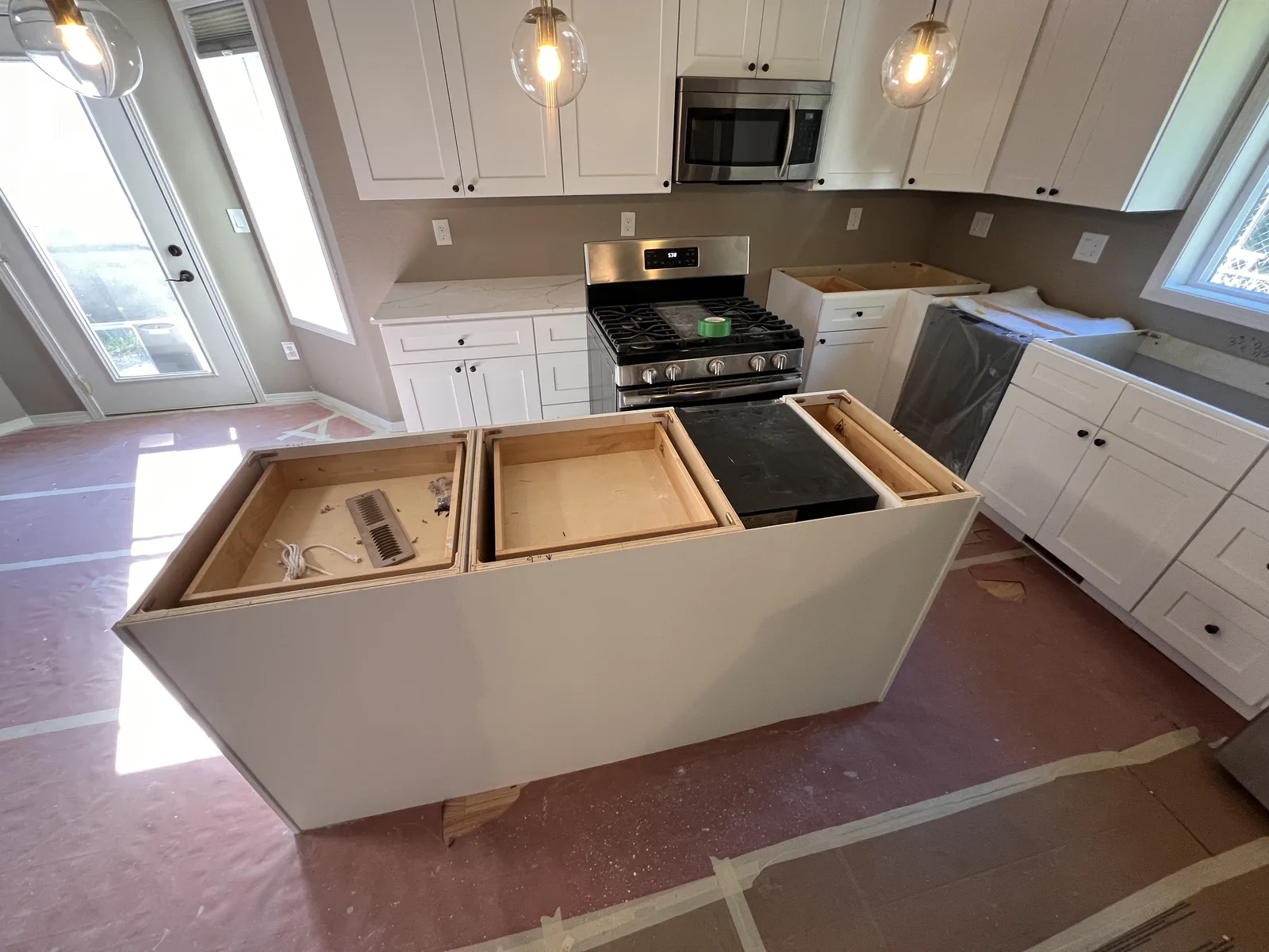 Kitchen base cabinets and island cleared after the old countertops were removed