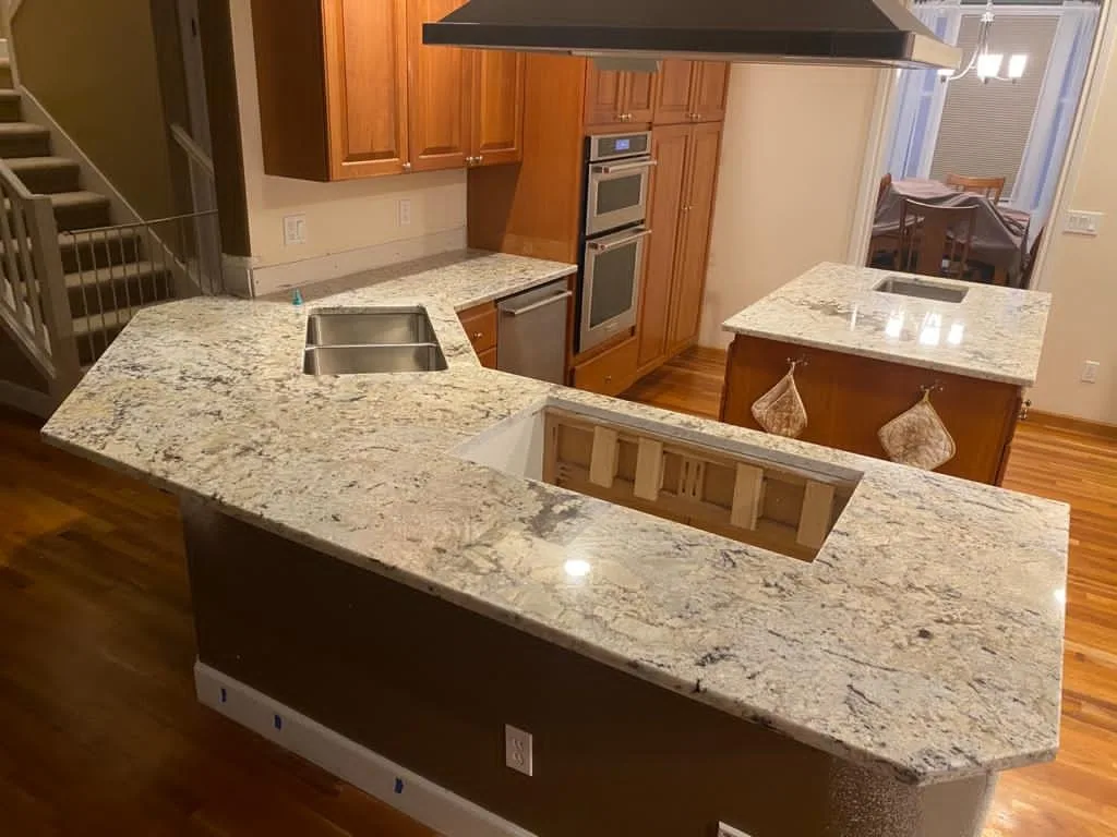 Warm stone, warm wood, a kitchen that feels like home. A Top Granite project