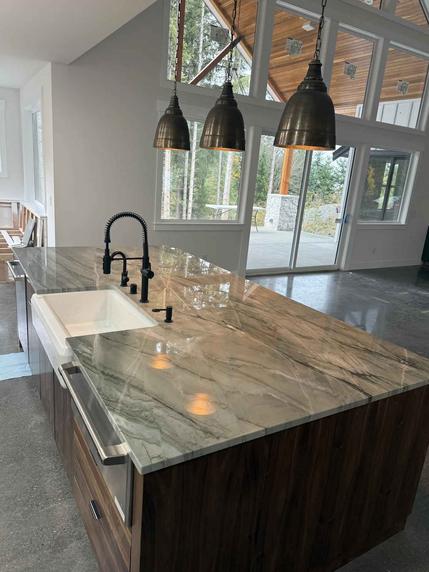 Green quartzite island under a high ceiling. A Top Granite project
