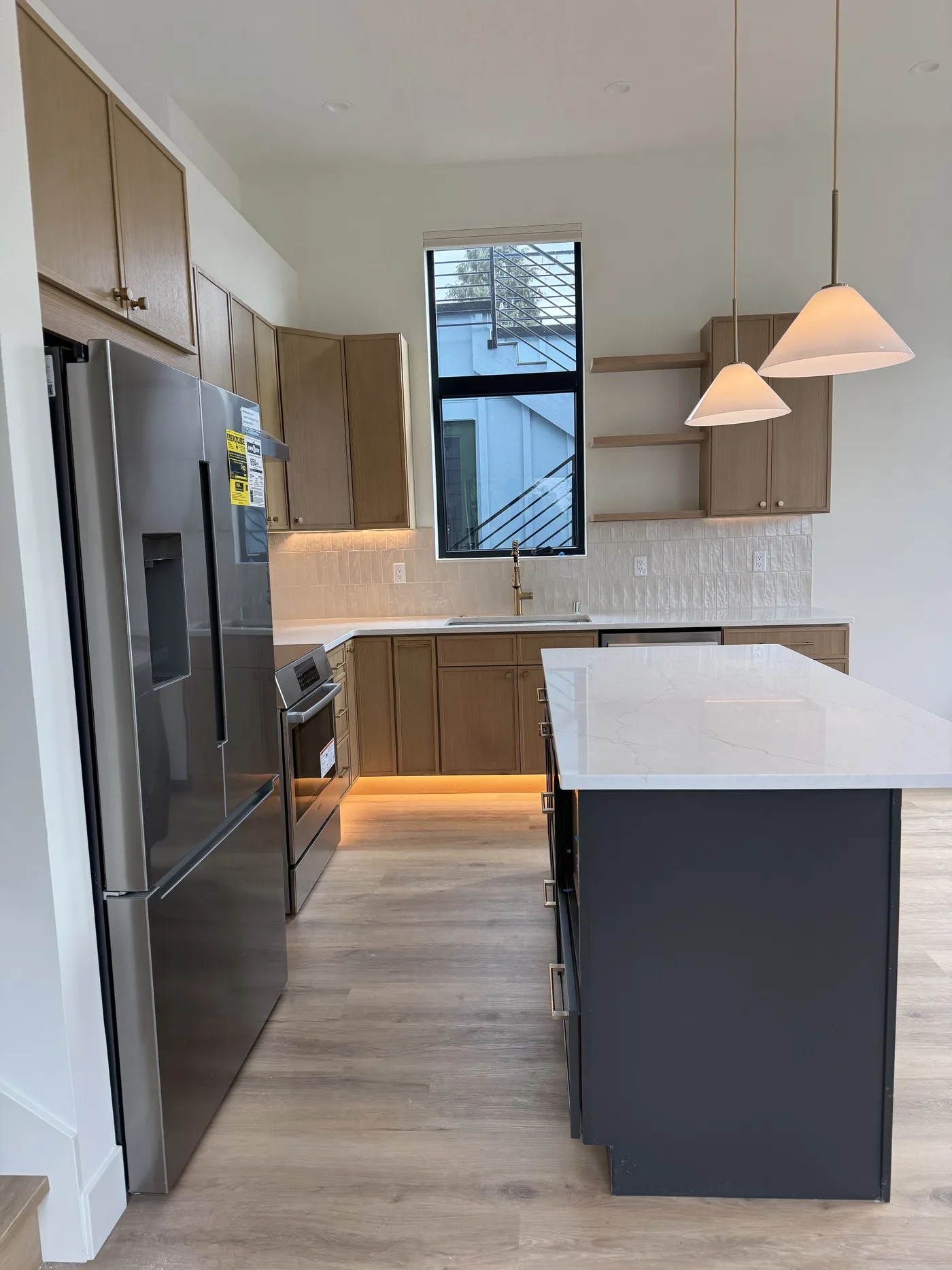 Light wood kitchen with an island and pendants. A Top Granite project