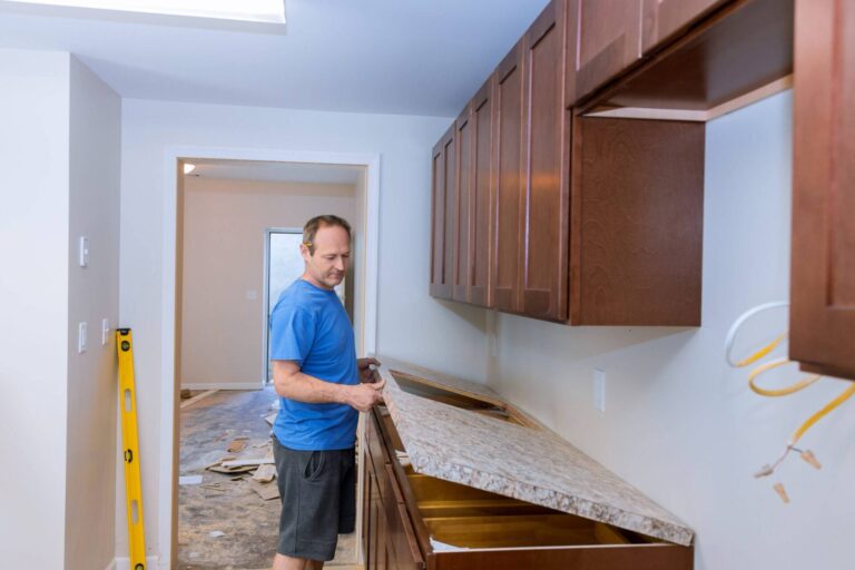 A man carefully performing countertop demolition in a kitchen using professional tools